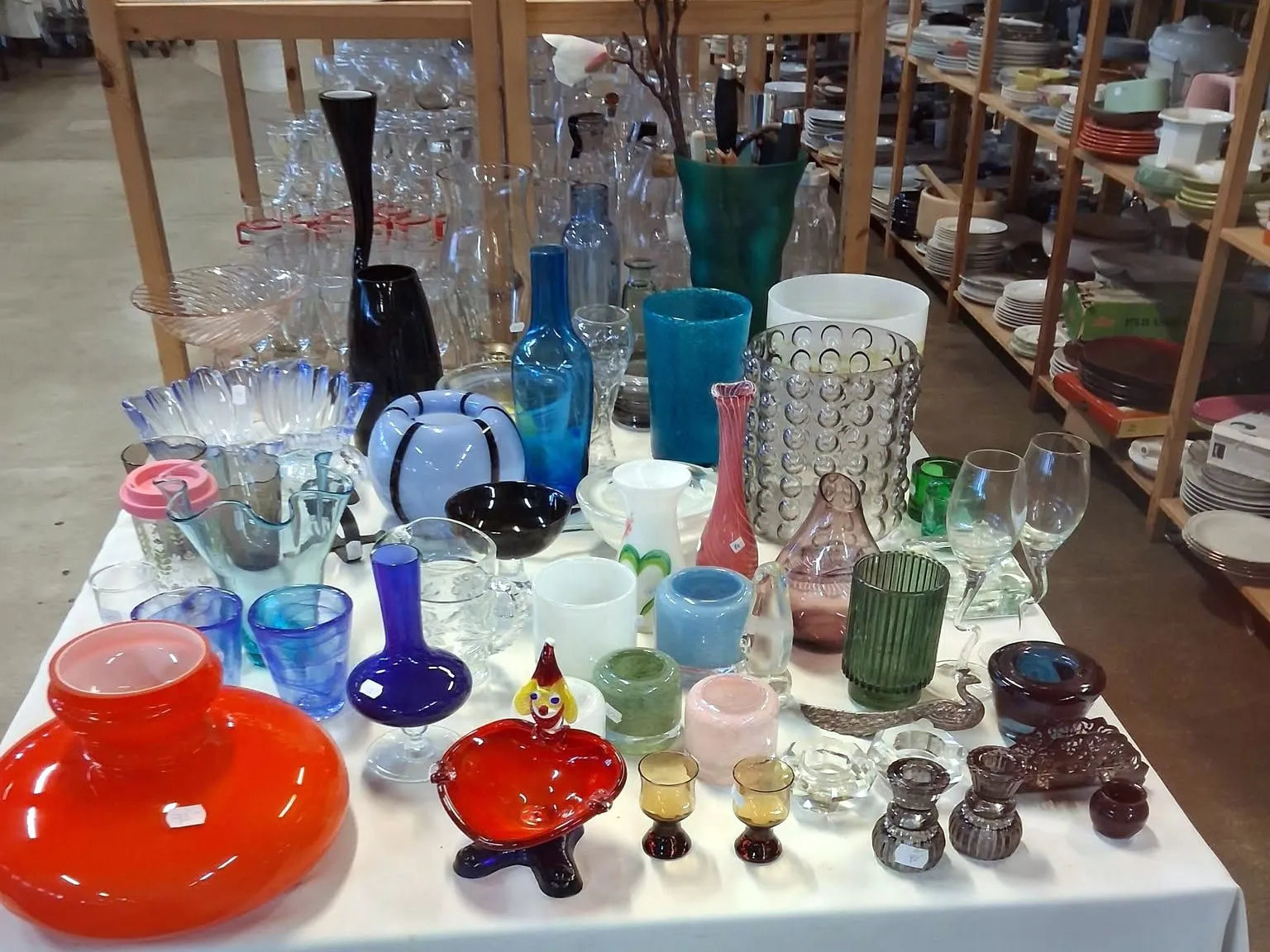 Bord med glas och konstglas i olika färger i Emmpatus Åkvarns second hand-butik i Torpsbruk