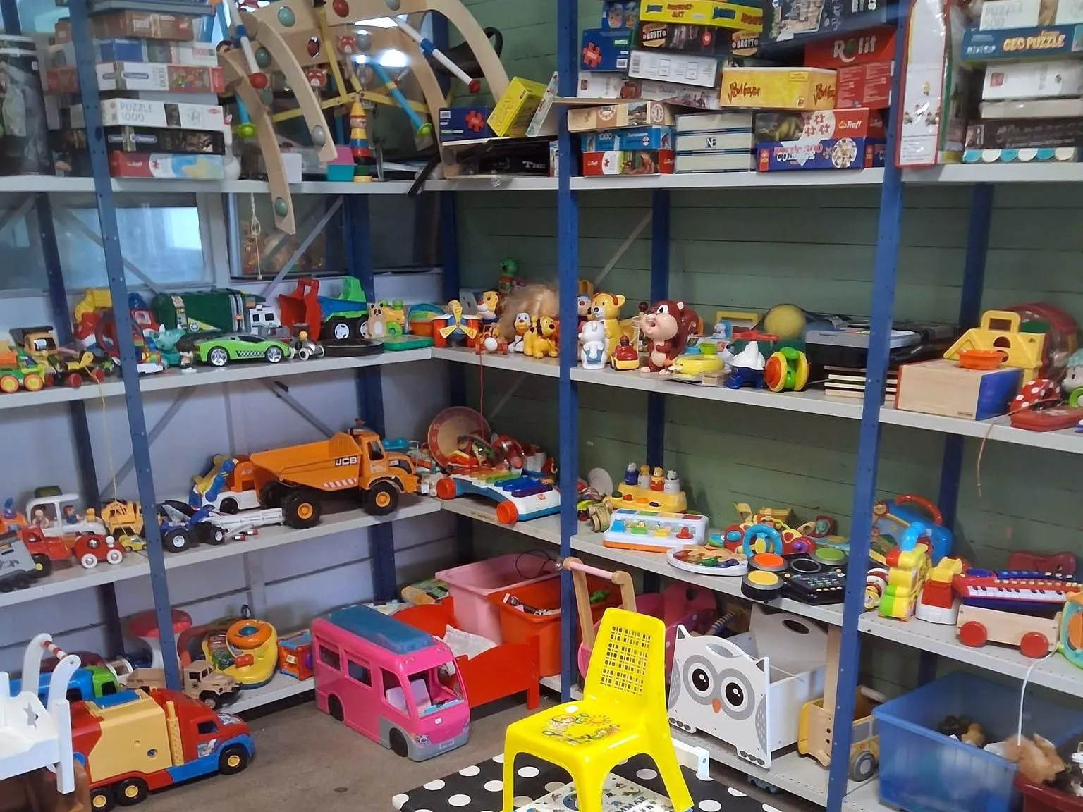 Hyllor med begagnade leksaker, spel och ett barnbord i Emmpatus Åkvarns second hand-butik i Torpsbruk