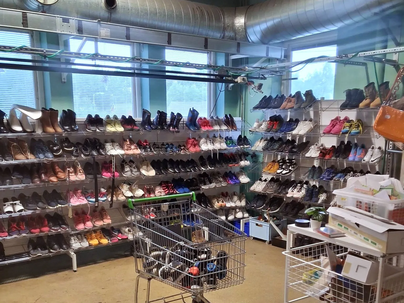 Skor uppradade på hyllor längs väggen i Emmpatus Åkvarns second hand-butik i Torpsbruk